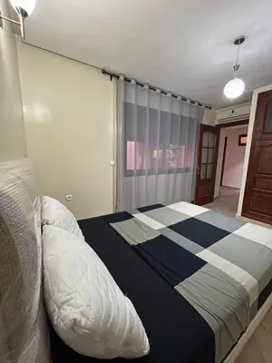 a bedroom with a bed with a black and white blanket at Apartment in Gueliz in Marrakech