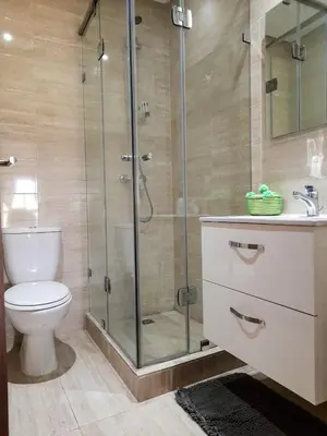 a bathroom with a toilet and a glass shower at Luxury Apartments in Marrakech