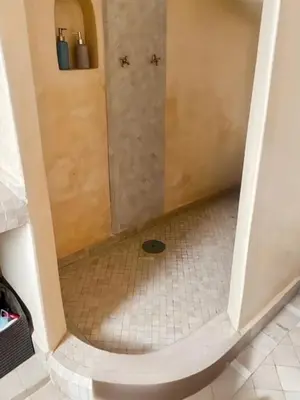a shower in a bathroom with a tiled floor at Riad coup de coeur, Medina, Marrakech in Marrakech