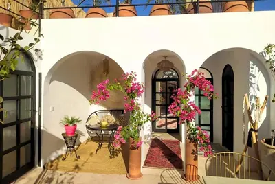 a courtyard with a table and pink flowers at Little date in Marrakech