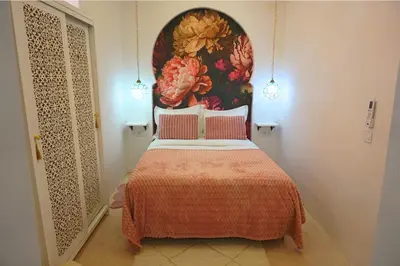 a bedroom with a bed with a painting on the wall at Little date in Marrakech