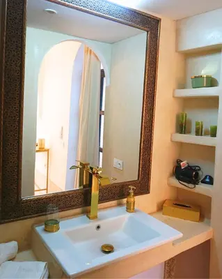 a bathroom with a sink and a large mirror at Little date in Marrakech