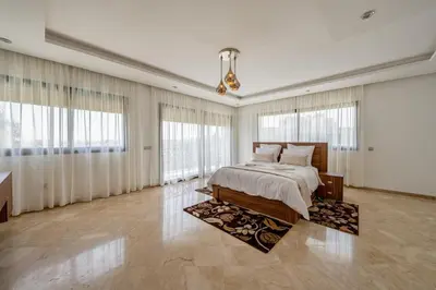 a large bedroom with a bed and large windows at Golf Resort 4BR Villa Heated Pool Free Pickup in Marrakech