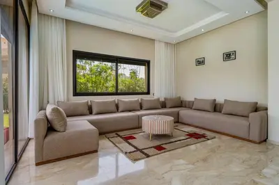 a living room with a couch and a table at Golf Resort 4BR Villa Heated Pool Free Pickup in Marrakech