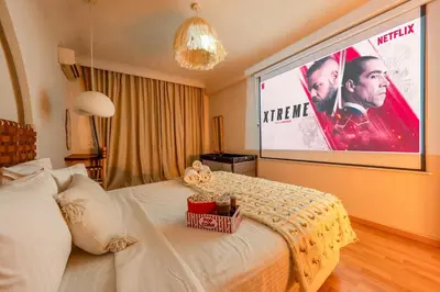 a bedroom with a large screen with a movie at Secure Stylish Flat Gueliz Pool WiFi Parking in Marrakech