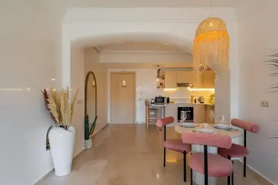 a kitchen and dining room with a table and chairs at Secure Stylish Flat Gueliz Pool WiFi Parking in Marrakech
