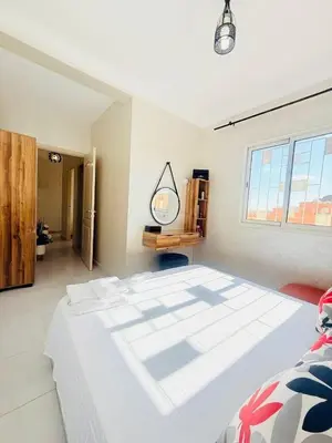 a bedroom with a large white bed and a mirror at TheCosyCorner in Marrakech