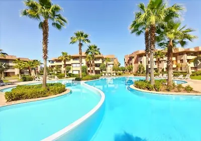 a swimming pool with palm trees in a resort at Elegant Studio-Prestigia Agate in Marrakech
