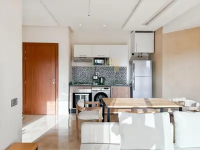 a kitchen and dining room with a wooden table at Elegant Studio-Prestigia Agate in Marrakech