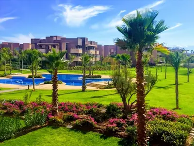 a park with palm trees and a resort in the background at Elegant Studio-Prestigia Agate in Marrakech