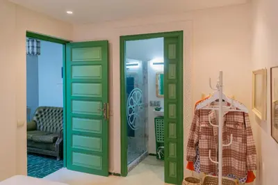 a room with green doors and a room with a chair at Riad Dar 77 in der Medina mit Terrasse in Marrakech