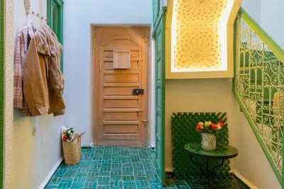 a hallway with a door and a table with flowers at Riad Dar 77 in der Medina mit Terrasse in Marrakech