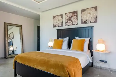 a bedroom with a large bed with orange pillows at Modern Golf Retreat Heated Pool & Free breakfast in Marrakech