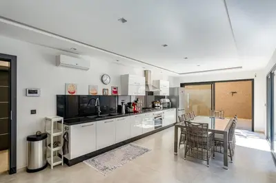 a kitchen with a table and a dining room at Modern Golf Retreat Heated Pool & Free breakfast in Marrakech