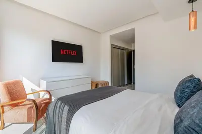 a bedroom with a bed and a tv on the wall at Modern Golf Retreat Heated Pool & Free breakfast in Marrakech