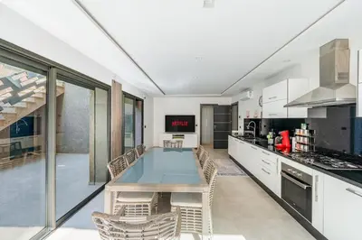 a kitchen with a table and chairs in a room at Modern Golf Retreat Heated Pool & Free breakfast in Marrakech
