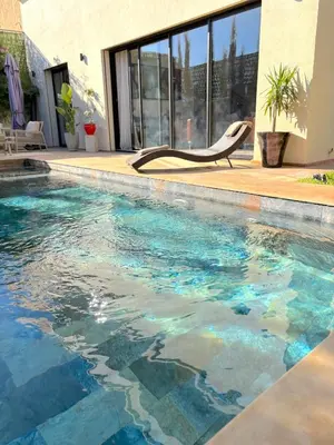 a swimming pool with a chair in front of a building at Palais Naya in Marrakech