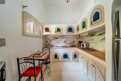 a kitchen with a counter and a table and chairs at New Stylish Riad - 4BR with Pool Access Free Breakfast & Airport Pickup in Marrakech