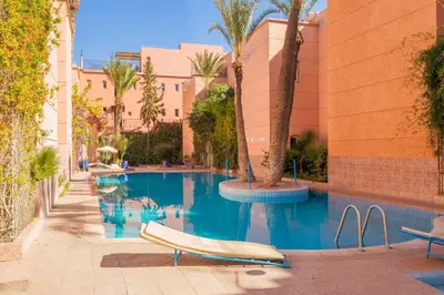 a swimming pool with a boat in front of a building at New Stylish Riad - 4BR with Pool Access Free Breakfast & Airport Pickup in Marrakech