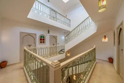a large staircase in a home with white walls at New Stylish Riad - 4BR with Pool Access Free Breakfast & Airport Pickup in Marrakech