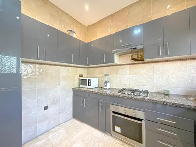 a kitchen with gray cabinets and a counter top at Villa Andalus - Piscine privée & Suite Parentale in Marrakech