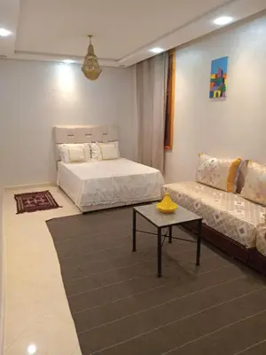 a living room with two beds and a couch at Chambre dans un Maison traditionnel avec jardin système de riad dans une ambiance familiale marocain in Marrakech