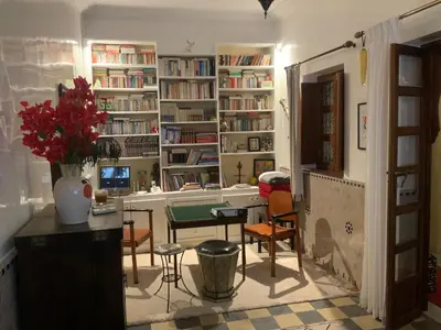 a room with a table and chairs and bookshelves at Riad Marhaba Kasbah in Marrakech