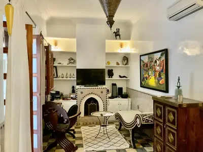 a living room with a fireplace and a table at Riad Marhaba Kasbah in Marrakech