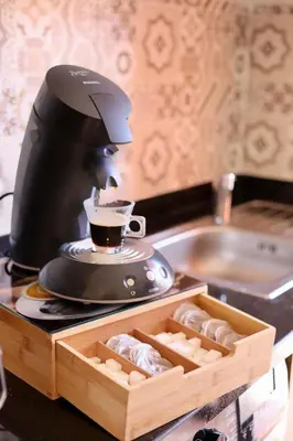 a coffee maker sitting on a counter next to a box of cookies at Appart cosy & chic premium Village, 5 piscines in Marrakech