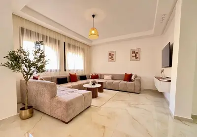 a large living room with a couch and a table at Appart cosy & chic premium Village, 5 piscines in Marrakech
