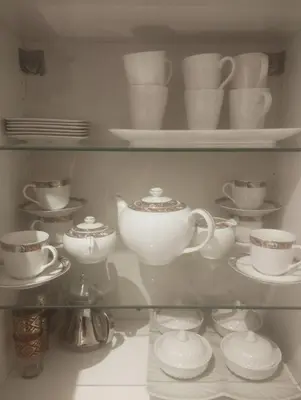 a shelf filled with cups and saucers and dishes at Cocon chaleureux proche commerces et centre in Marrakech