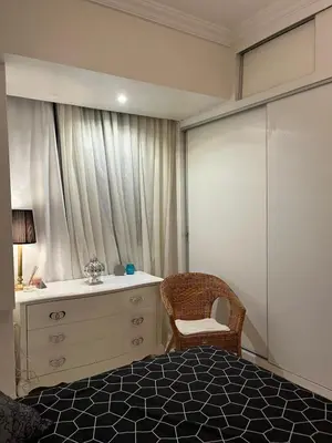 a bedroom with a bed and a dresser and a window at Cocon chaleureux proche commerces et centre in Marrakech