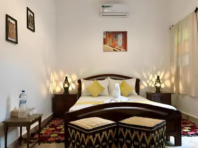 a bedroom with a bed with two tables and a window at Riad Iklil Hce in Marrakech