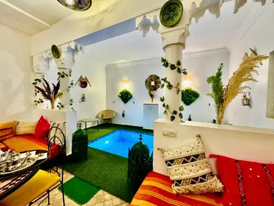 a living room with a pool in the middle at Riad Iklil Hce in Marrakech