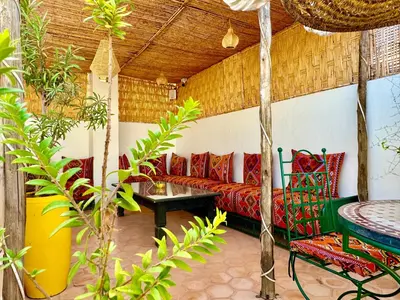 a living room with a red couch and a table at Riad Iklil Hce in Marrakech