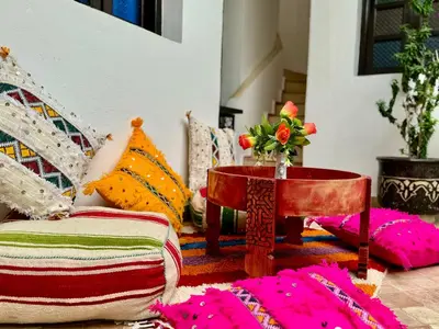 a room with a table with a vase of flowers on it at Riad Iklil Hce in Marrakech