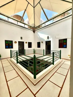 an indoor arena with a glass ceiling and green railing at Riad Iklil Hce in Marrakech
