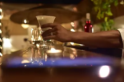 a person holding a drink on a bar at Riad Iklil Hce in Marrakech