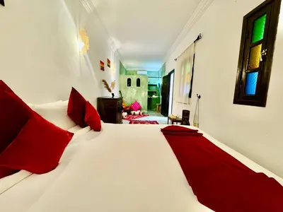 a bedroom with a large white bed with red pillows at Riad Iklil Hce in Marrakech