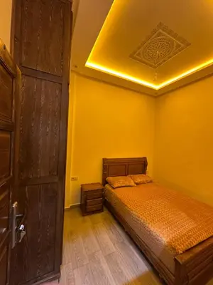 a bedroom with a bed and a wooden door at Studio tranquille dans le village touristique in Marrakech