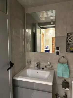a bathroom with a white sink and a mirror at Studio tranquille dans le village touristique in Marrakech