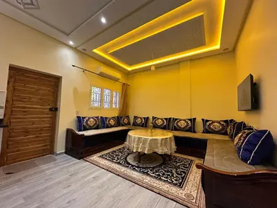a living room with a couch and a table at Studio tranquille dans le village touristique in Marrakech