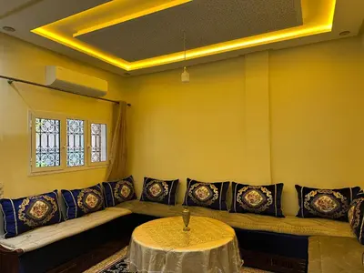 a living room with a couch and a table at Studio tranquille dans le village touristique in Marrakech
