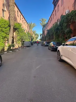 a street with cars parked on the sides of the road at Studio tranquille dans le village touristique in Marrakech