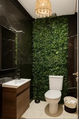a bathroom with a toilet and a green wall at Cocon Zen in Marrakech
