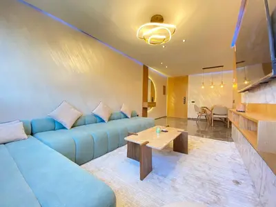 a living room with a blue couch and a table at Chic garden & grand balcon in Marrakech
