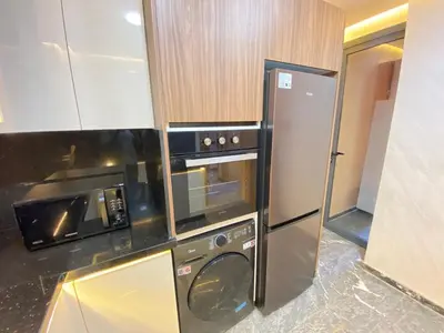 a kitchen with a microwave and a washer and dryer at Chic garden & grand balcon in Marrakech