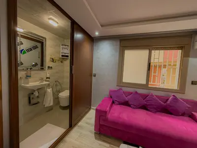 a purple couch in a bathroom with a sink at Essalmi Duplex Apartment in Marrakech in Marrakech