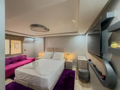 a bedroom with a white bed and a pink couch at Essalmi Duplex Apartment in Marrakech in Marrakech