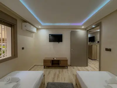 a room with two beds and a tv on the wall at Essalmi Duplex Apartment in Marrakech in Marrakech